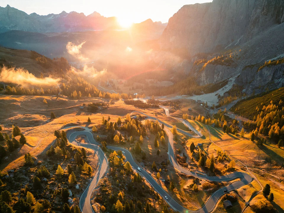 Sunrise over winding roads and autumn mountains