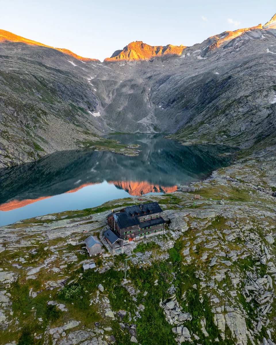 Mountain lake below rocky peaks in the first sunlight